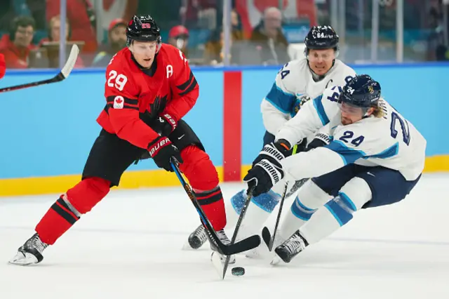 Nathan MacKinnon of Team Canada compete for the puck against Roope Hintz