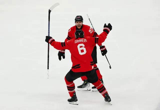 Shea Theodore #27 of Team Canada celebrates with teammate Travis Sanheim #6 after scoring a goal in the third period during the Men's Semifinals Playoff match between Canada and Finland on day fourteen of the Milano Cortina 2026 Winter Olympic games at Milano Santagiulia Ice Hockey Arena