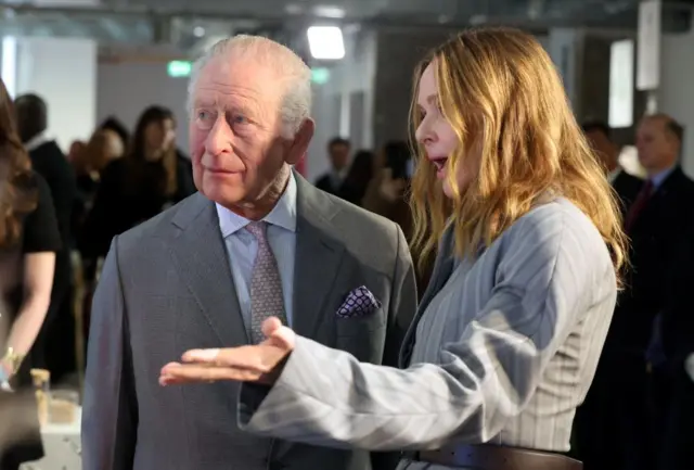 Britain's King Charles talks with designer Stella McCartney at the London Fashion Show, in London