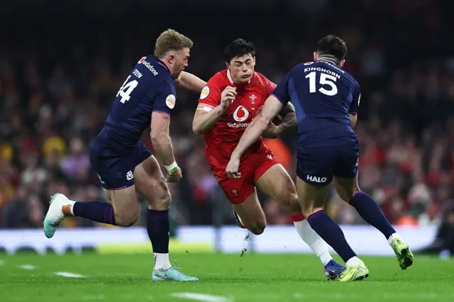 Louis Rees-Zammit is tackled by Blair Kinghorn and Kyle Steyn