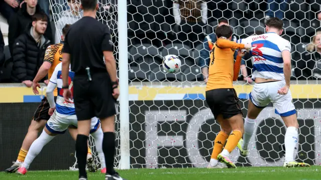 The ball goes in the net as Hull and QPR players watch on