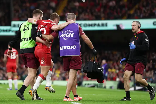 Sam Costelow is helped off the pitch