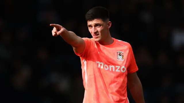 Coventry's Bobby Thomas holds his right arm out and points his finger while standing on the pitch