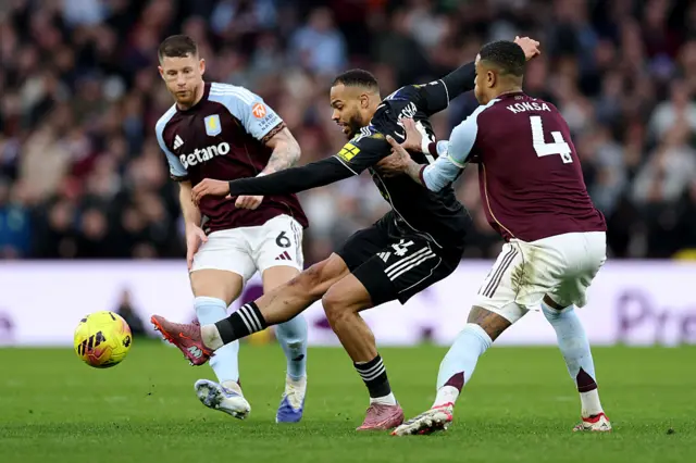 Lukas Nmecha of Leeds United takes a shot whilst under pressure from Ezri Konsa and Ross Barkley