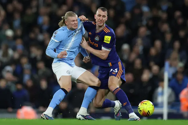 Manchester City's Norwegian striker #09 Erling Haaland (L) vies with Newcastle United's English defender #33 Dan Burn