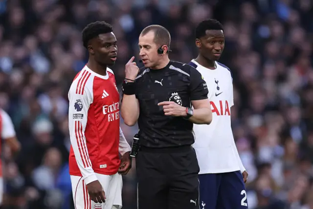 Referee Peter Bankes speaks to Bukayo Saka of Arsenal