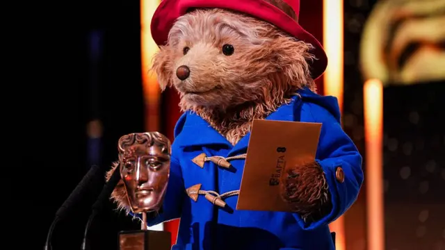 Paddington presents an award at the Baftas