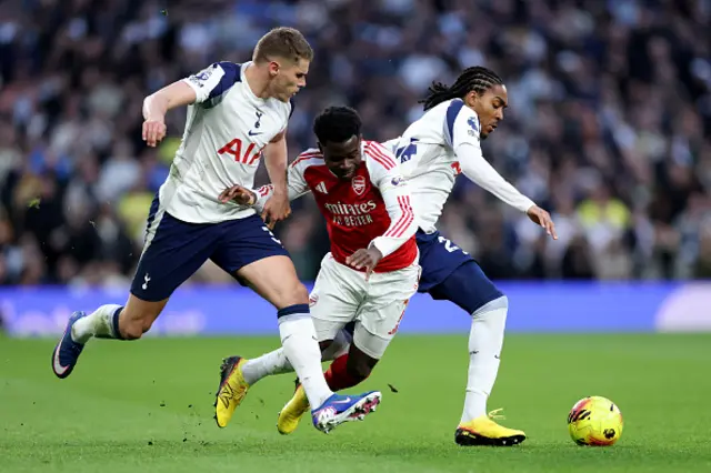 Bukayo Saka of Arsenal runs with the ball whilst under pressure from Micky van de Ven and Djed Spence