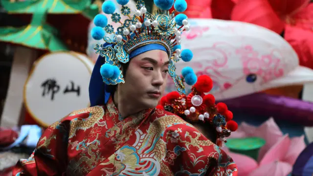 Person in traditional clothing and head piece at Chinese New Year parade in London