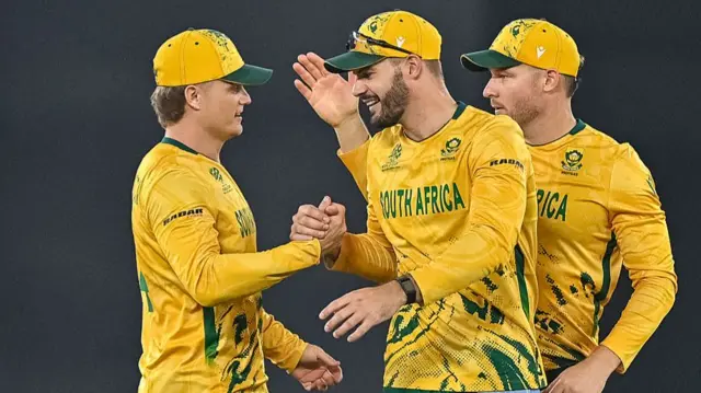 South Africa's captain Aiden Markram (C) celebrates with teammates Ryan Rickelton (L) and David Miller (R) after their team's win