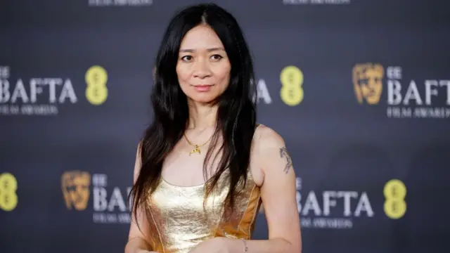 Chloe Zhao in a gold dress on the Baftas red carpet