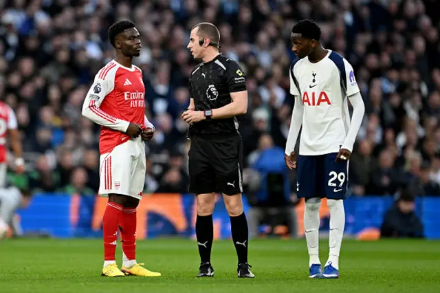 Referee Peter Bankes interacts with Bukayo Saka of Arsenal and Pape Matar Sarr of Tottenham Hotspur