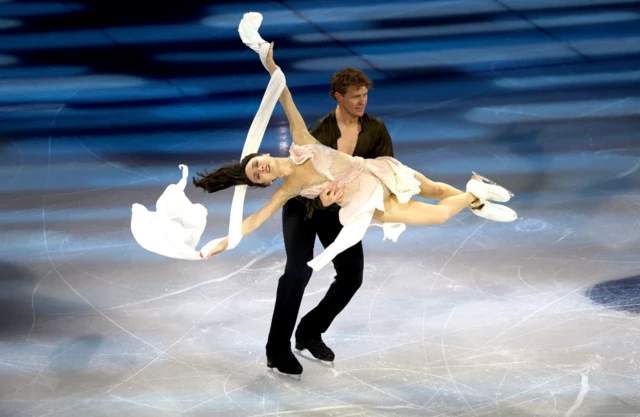 Two dancers on ice, the male dancer holding the female in his arms