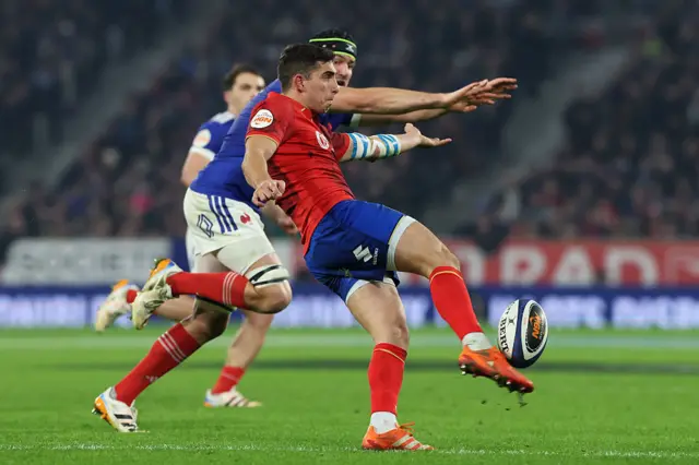 Alessandro Fusco of Italy kicks the ball clear up field whilst under pressure from Francois Cros of France