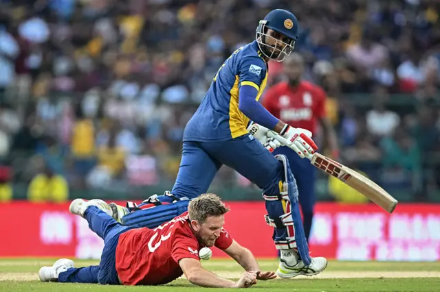 England's Liam Dawson (bottom) dives to field the ball as Sri Lanka's captain Dasun Shanaka runs between the wickets