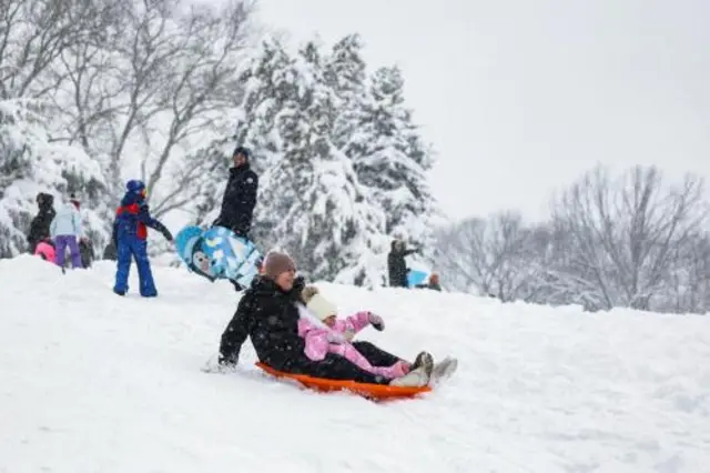 People sledding on fresh snow