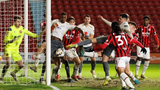 Jon Mellish pokes in MK Dons' second goal against Walsall