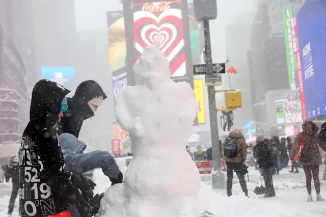 People building a snowman in Times Square