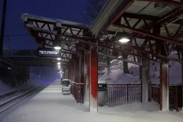 A train platform is covered in snow during a winter storm at the Manhasset transportation station in Manhasset, New York