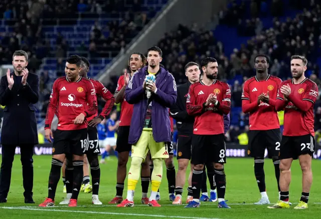 Carrick and his players stand and applaud the away end after full time