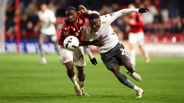 Walsall's Courtney Clarke battles with Rushian Hepburn-Murphy of MK Dons