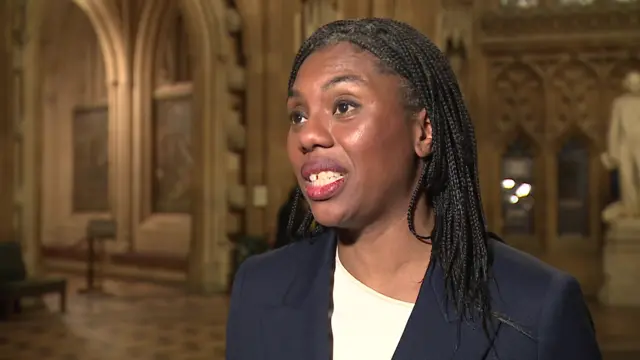Kemi Badenoch speaking, wearing a navy suit jacket on top of a white top