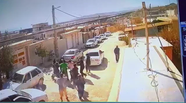 CCTV footage of people fighting in the street as a car drives away