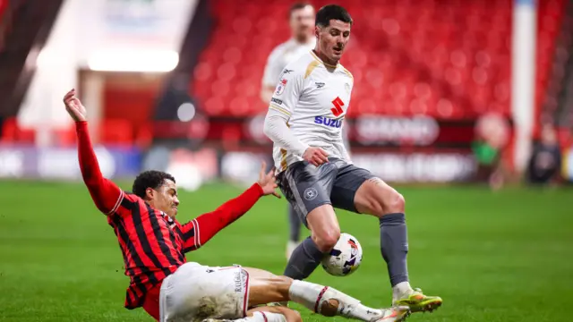 Priestley Farquharson of Walsall slides in to tackle MK Dons' Jon Mellish