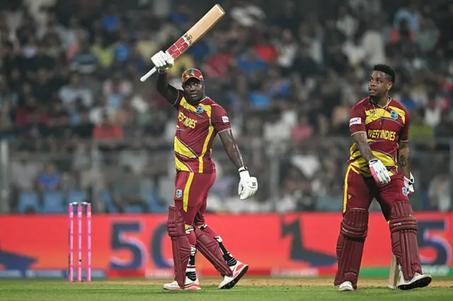Rovman Powell (L) celebrates his half-century