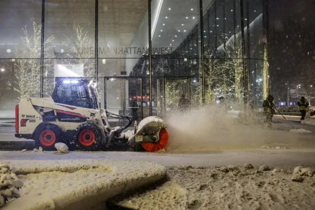 A snow plough vehicle clears snow as it falls during a winter storm in New York City, 22 February.
