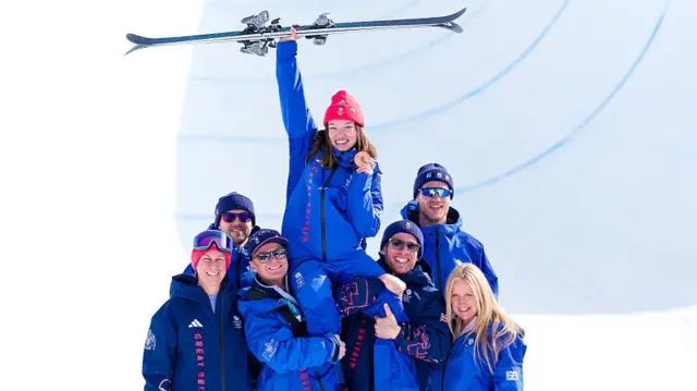 Zoe Atkin with here skis aloft