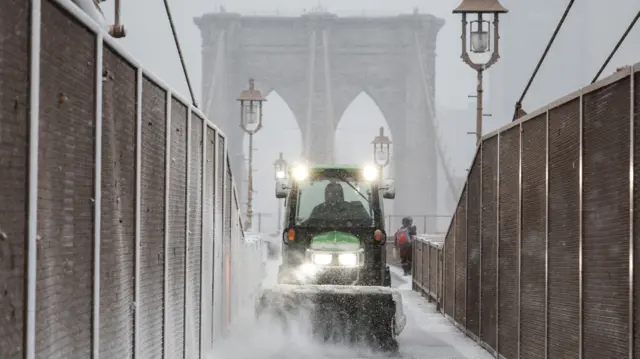 A snow plow clearing Brooklyn Bridge on Sunday