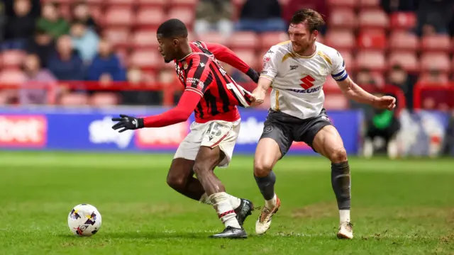Walsall's Daniel Kanu has his shirt pulled by Alex Gilbey