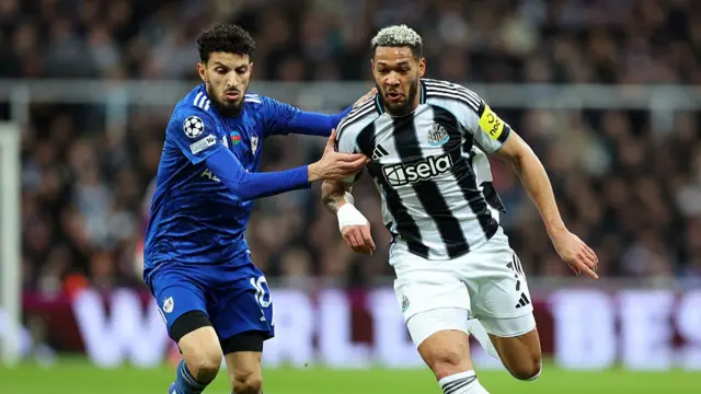 Joelinton of Newcastle United in action with Abdellah Zoubir of Qarabag FK during the UEFA Champions League 2025/26 League Knockout Play-off Second Leg match between Newcastle United FC and Qarabag FK at St James' Park