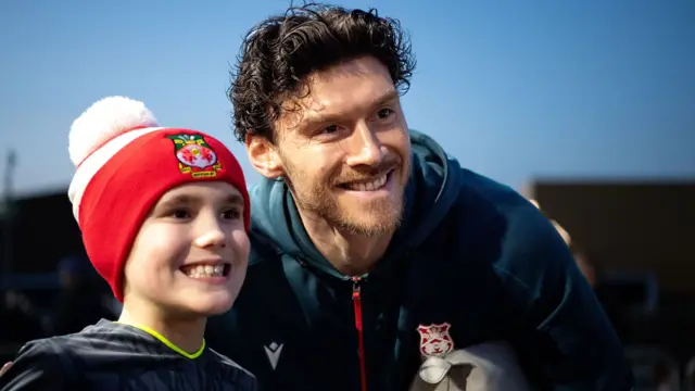 Wrexham striker Kieffer Moore poses for a photo with a young fan