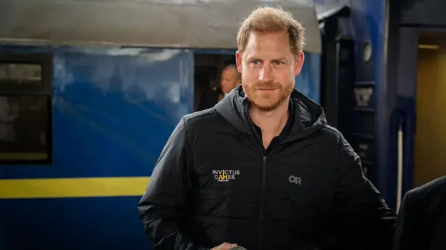 Prince Harry in front of a train in Kyiv