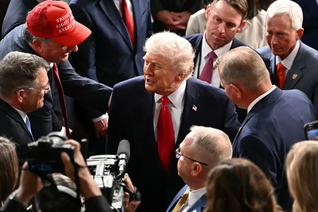 Donald Trump surrounded by US lawmakers after giving his State of the Union address