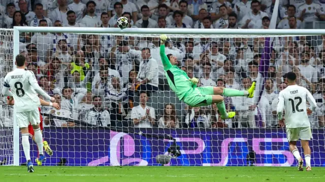 Thibaut Courtois reaches as the ball hits the bar
