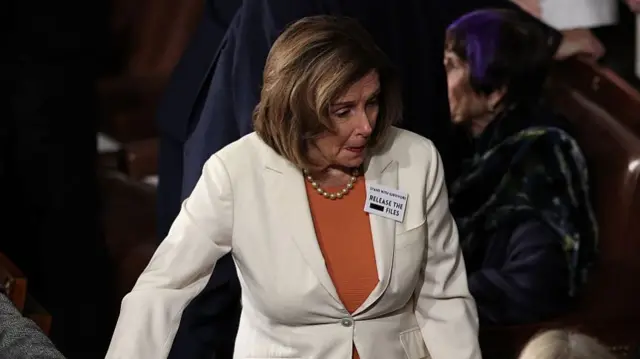 Nancy Pelosi wears badge that reads: "Stand with survivors. Release the files"