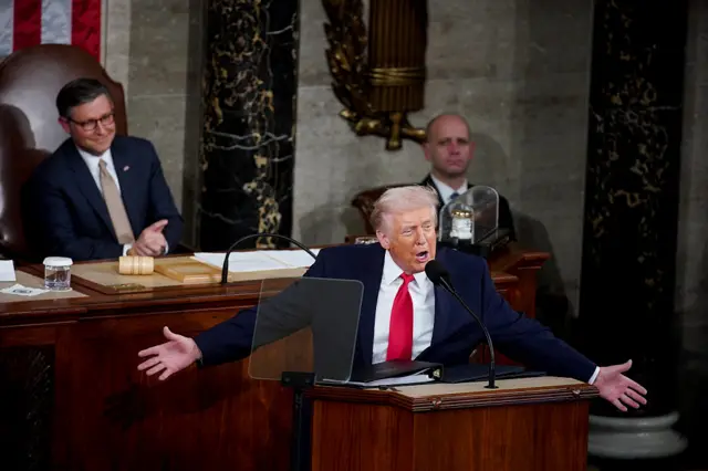 Donald Trump, arms outstretched gives a speech