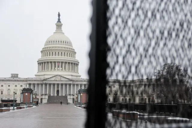 The US Capitol partially obscured by a security fence