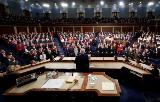 President Donald Trump, seen from behind, stands before a joint session of Congress