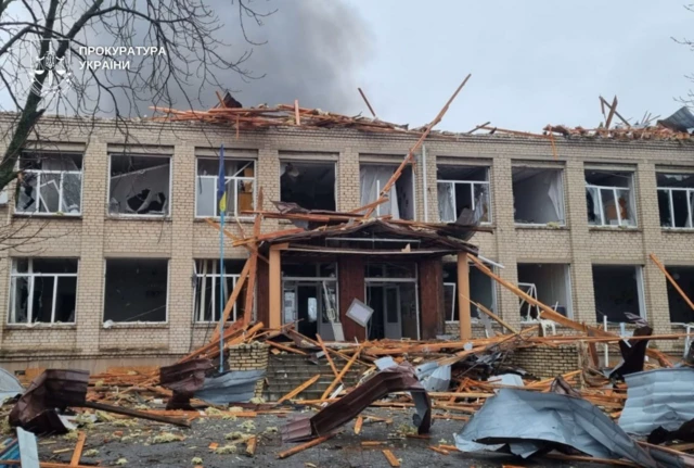 A school which has been hit by a strike, the roof is destroyed, the windows are blown out and debris is scattered around