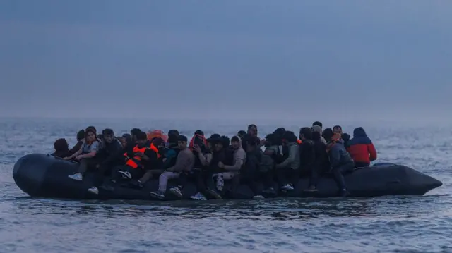 Lots of people aboard a small boat on the English channel