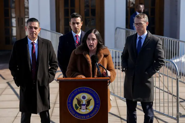 Rep Yassamin Ansari speaks behind a lectern with fellow Democrats by her side