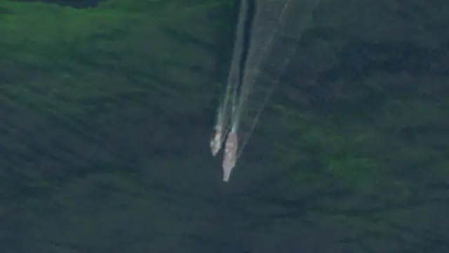 Two ships, one of which is USS Abraham Lincoln, sailing close together