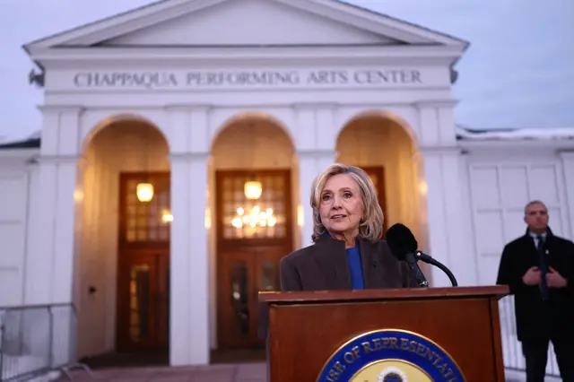 Hillary Clinton outside a large white pillared building