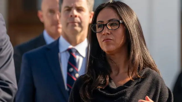 Boebert outside the Clinton hearing today. She wears a black top.