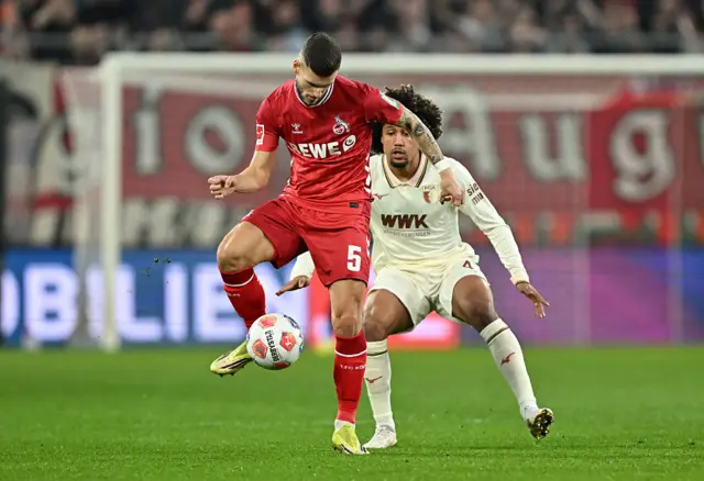 Tom Krauss of 1. FC Koln controls the ball whilst under pressure from Han-Noah Massengo of FC Augsburg