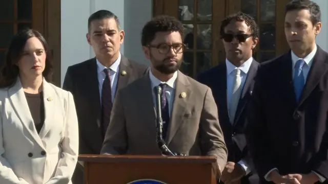 Maxwell Frost speaking into microphone with other Democrats standing behind him
